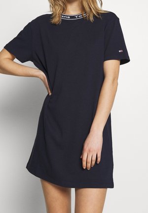 Robe t-shirt en coton bleu marine avec un col rond, dotée d'une bande logo blanche contrastante et d'une coupe ample et décontractée.