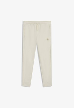Pantaloni jogger beige chiaro realizzati in un materiale morbido, con vita elasticizzata, tasche laterali e una piccola etichetta con logo sul davanti.