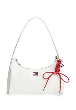 Weiße Handtasche mit einem einzelnen Träger, Tommy Jeans Logo und einer roten, geflochtenen Schnur mit Schleife und silbernem Herzanhänger, der an der Seite hängt.