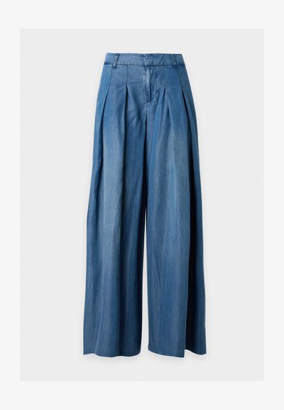 Pantalon large en denim bleu taille haute avec plis et passants de ceinture, présenté à plat sur un fond blanc uni.