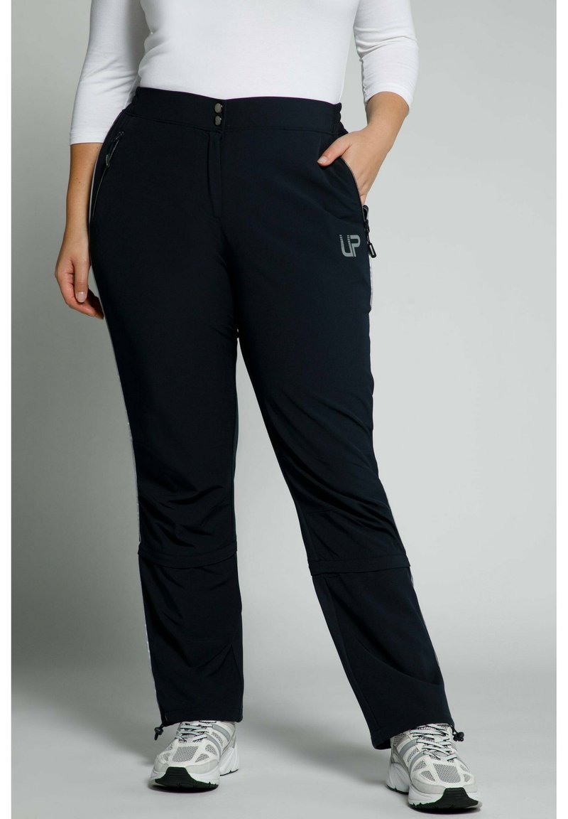 Černé kalhoty z elastického materiálu se zipovými kapsami, slim fit a mírně rozšířeným střihem nohavic. Na přední straně je umístěno logo.