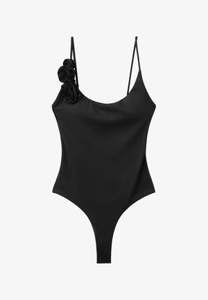 Body noir sans manches en forme de string avec fines bretelles et trois embellissements en tissu en forme de roses sur la bretelle gauche.