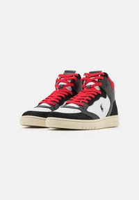 Vysoké tenisky s černým semišem, bílou kůží a červenými tkaničkami. Výrazné logo na boku, s texturovanou gumovou podrážkou a perforovanou špičkou.