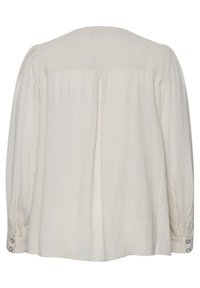 Blusa a maniche lunghe di colore crema, con schiena plissettata, polsini abbottonati e tessuto liscio e leggero. Design semplice con una vestibilità comoda.