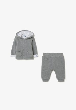 Chaqueta de punto gris con capucha y forro blanco, dos bolsillos frontales y cierre de botón, combinada con pantalones grises a juego con cintura elástica.