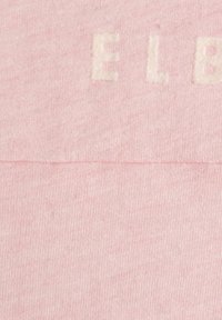 Lichtroze sweatshirtstof met een reliëfontwerp in witte tekst. De textuur lijkt zacht en enigszins gemêleerd met subtiele variaties.