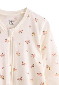 Bílé dětské body z látky s květinovým potiskem drobných růžových a žlutých květin. Zapínání na zip vpředu, měkká bavlněná textura.