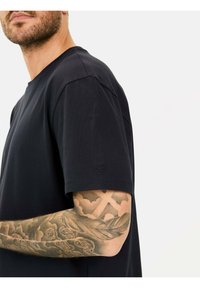 Zwarte katoenen t-shirt met een ronde hals en korte mouwen. Bevat een subtiele logodetail op de linker mouw. Gladde textuur.