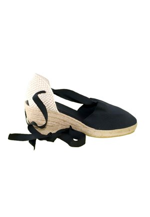 Alpargata negra de cuña única con tacón tejido beige y cintas negras para atar en el tobillo sobre fondo blanco.
