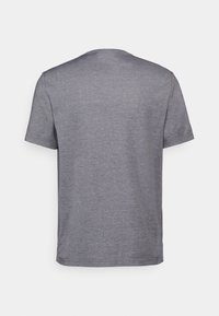 Camiseta gris de manga corta con cuello redondo, confeccionada en una tela suave. Presenta una textura lisa y un corte casual, sin logotipos visibles.