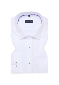 Camicia bianca in tessuto liscio, con colletto classico, chiusura a bottoni e polsi singoli. Dettagli a contrasto all'interno del colletto.