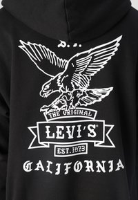 Felpa nera con grafica di un'aquila bianca e logo "Levi's" con testo "California". Realizzata in morbido cotone.