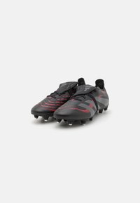 Black soccer cleats with red accents, featuring a sleek design and textured surface. Includes a lace-up closure and durable studs for traction.