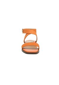 Orange leather sandal with a cross-strap design and ankle buckle, featuring a flat sole and a smooth texture.