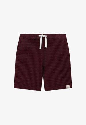 Shorts texturés rouge foncé avec taille élastique et cordon blanc, avec une petite étiquette blanche en bas à droite de l'ourlet.