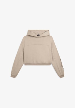 Felpa corta beige con cappuccio, maniche lunghe e polsini a costine. Presenta un dettaglio di cucitura sul petto e un testo sulla manica sinistra.