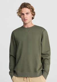 Felpa verde oliva con scollatura rotonda, orlo e polsini a costine, caratterizzata da una texture liscia e maniche lunghe.