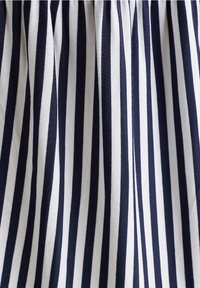 Tissu rayé verticalement bleu marine et blanc avec une texture douce, présentant des rayures régulièrement espacées de largeurs variées, froncées en haut.