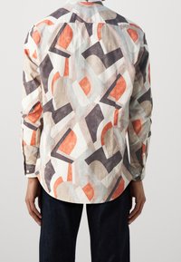 Camicia a maniche lunghe in tessuto leggero con un motivo geometrico astratto arancione, grigio e beige, orlo curvo e polsini abbottonati.