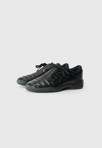 Schwarze Ledersneaker mit einem gepolsterten Design, runder Zehenpartie und Schnürverschluss. Mit einer dunklen Gummisohle und dezentem Markenlogo.