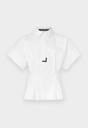 Cămașă albă cu mâneci scurte și guler, având închidere frontală cu nasturi și un detaliu accent negru la guler. Croială ajustată.