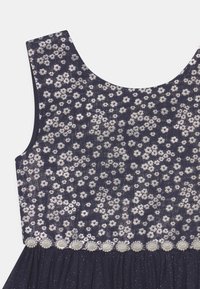 Marineblaues Kleid mit floralem Muster in Silber, das ein tailliertes Oberteil, einen weiten Ausschnitt und einen Rock mit perlenähnlichen Akzenten aufweist.