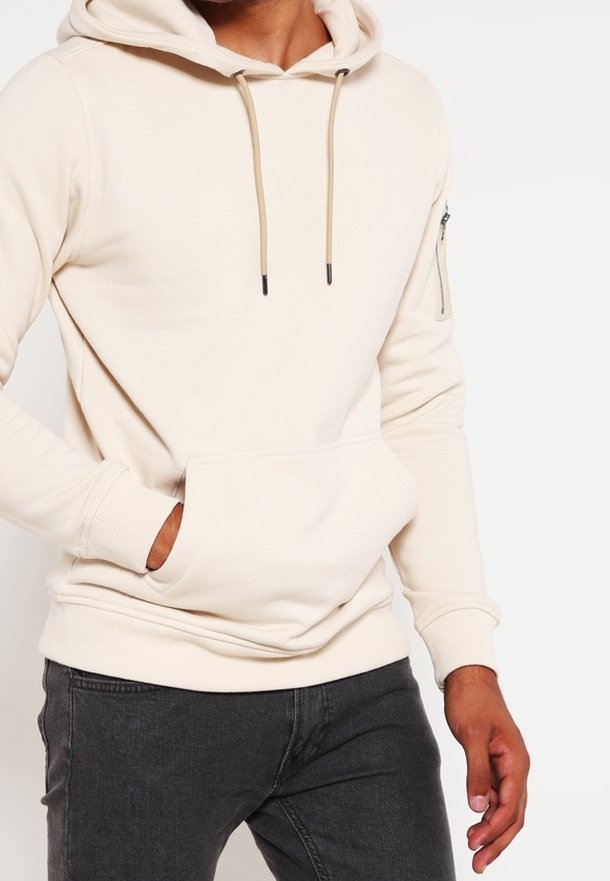 Beige hoodie met een trekkoord, een voorzak en een ritszak op de mouw. Gemaakt van zacht materiaal, met ribbelboorden en een ribbelonderkant.