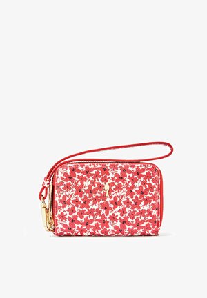 Czerwona portmonetka w kwiaty z gładką teksturą, złotymi akcentami, zapięciem na zamek błyskawiczny i odpinanym paskiem na nadgarstek; zdobiona białym wzorem kwiatowym.