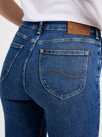 Blauwe denim jeans met een gladde textuur, voorzien van gouden stiknaden en een leren label bij de tailleband. Twee achterzakken met gebogen naden.