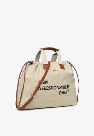 Bolsa tote de lona beige con asas y correa de cuero marrón, laterales con cordón y el texto "SOY UNA BOLSA RESPONSABLE" en letras negras.