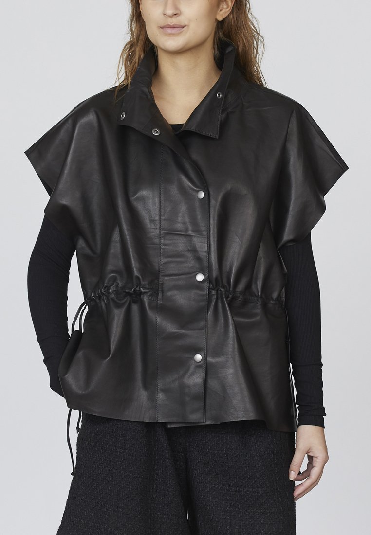 Sort læder oversized vest med korte ærmer, trykknapper og justerbar snøre i taljen. Glat tekstur med en struktureret silhuet.