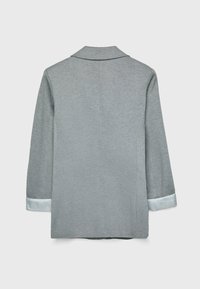 Šedý blejzr se hladkou texturou, s klopami a pruhovanými světle modrými manžetami. Zadní pohled ukazuje jednoduchý, dokonale padnoucí design.