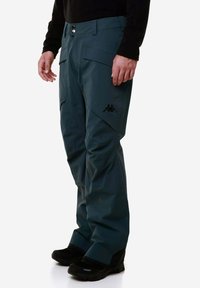 Pantaloni tecol di colore verde acqua, resistenti all'acqua e dal taglio relax, dotati di tasche cargo e di un logo nero sulla coscia. Completati da un bottone e passanti per la cintura.