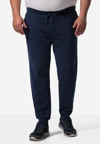 Marineblaue Jogginghosen aus weichem Stoff, mit einem elastischen Bund mit Kordelzug, seitlichen Taschen und schmal zulaufenden Bündchen.