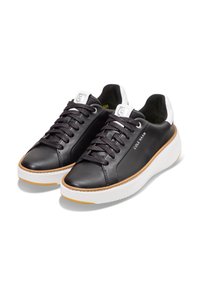 Schwarze Leder-Sneaker mit runder Zehenpartie, strukturierten Schnürsenkeln, weißer Zwischensohle und Gummisohle, mit einem seitlichen Logo und kontrastierenden Akzenten an der Rückseite.