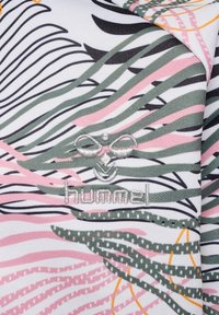 Textil mit einem weißen Hintergrund und pinken, grünen und schwarzen wellenförmigen Linien. Enthält ein gesticktes Logo "hummel" am unteren Rand.