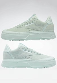 Jasno miętowe sneakersy o zamszowej fakturze, grubej podeszwie, perforowanym wykończeniu i logo po bokach. Niski krój z zawiązaniem na sznurówki.