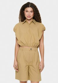 Khaki lühikesed käised ja nööbiga kroppitud särk, millele on juurde kombineeritud kõrge vöökoht ja kül pockets ning pleediga sobivad lühikesed püksid.
