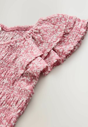 Rozā auduma topi ar ziedu rakstu, volānu piedurknēm, rievotu virskārtu un vieglu tekstūru. Tiek parādīts kakla izgriezuma detaļas skats.