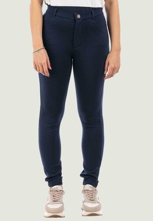 Pantaloni blu navy realizzati in un tessuto elasticizzato. Presentano una chiusura con bottone frontale, tasche laterali e una vestibilità affusolata con marchio lungo la gamba.