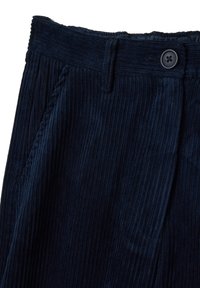 Marineblauwe corduroy broek met een ribbelstructuur, voorzien van een knoopsluiting bij de taille en zijzakken. Samengesteld met zichtbare details van het materiaal en de afwerking.
