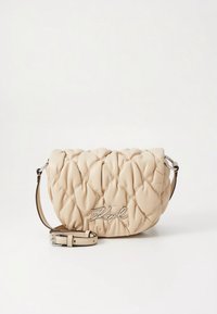 Beige quilted faux leather crossbody bag with a curved shape, silver hardware, a detachable strap, and a prominent logo detailing.