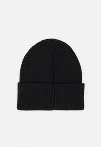 Beanie nero a maglia con risvolto e motivo testurizzato, realizzato in materiale morbido per il calore. Parte superiore rotonda con linee verticali sottili.