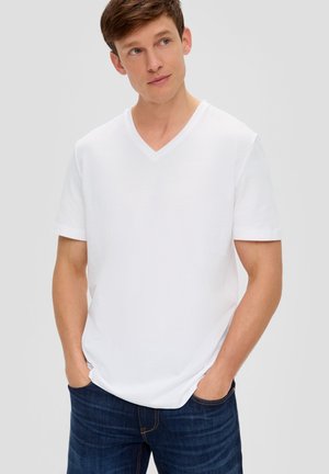 White short-sleeve V-neck t-shirt made of cotton, featuring a relaxed fit and smooth texture, paired with dark blue jeans.