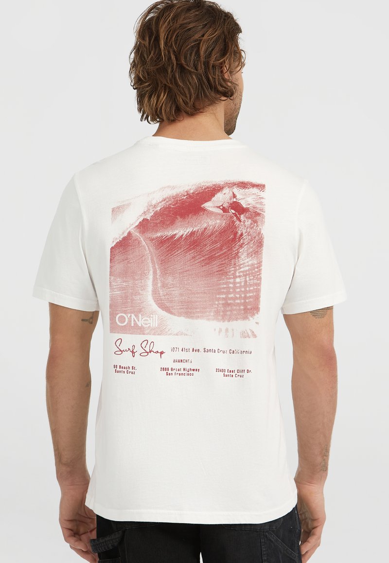 T-shirt in cotone bianco con una grafica rossa che raffigura un'onda e un surfista, con "O'Neill Surf Shop" e i dettagli della posizione stampati sotto.