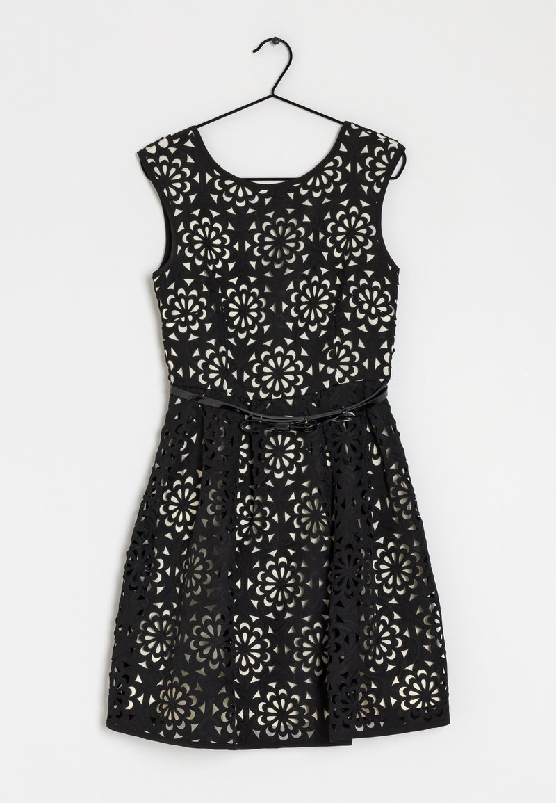Robe noire avec un motif floral découpé au laser, corsage ajusté et jupe évasée. Comprend une ceinture assortie pour cintrer la taille.