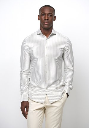 Witte en beige gestreepte shirt met een kraag en knoopsluiting, gemaakt van een gladde stof. Beschikt over lange mouwen en een getailleerd ontwerp.