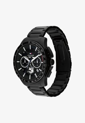 Montre-bracelet chronographe Tommy Hilfiger en acier inoxydable noir avec lunette tachymètre et trois sous-cadrans affichant les fonctions date et heure.