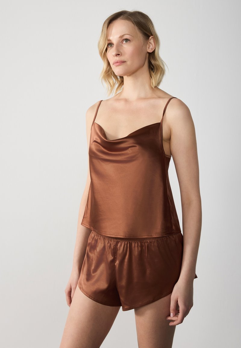 Bruine satijnen camisole met dunne bandjes, voorzien van een halslijn met levens, en loszittende bijpassende shorts, zachte textuur en elastische tailleband.