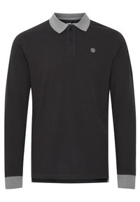 Svart langermet polo skjorte med grå krage og mansjettakenter. Har en tre-knappers knappestolpe og en liten logo på brystet.